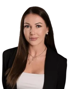 Modrá minimalistická ikona domečku s lupou, skrze lupu je vidět symbol dolaru.