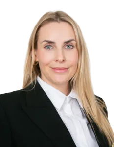 Modrá minimalistická ikona domečku s lupou, skrze lupu je vidět symbol dolaru.