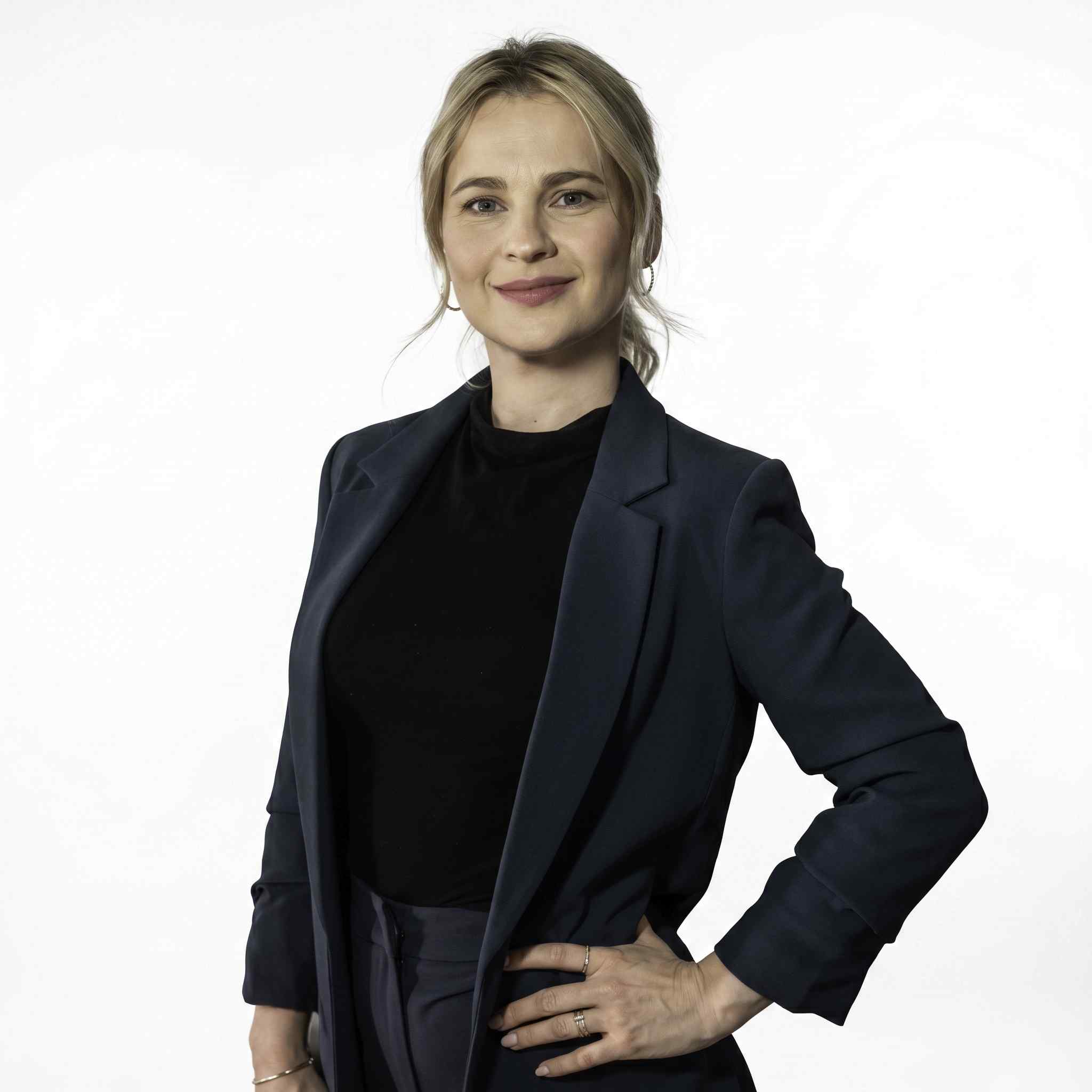 Modrá minimalistická ikona domečku s lupou, skrze lupu je vidět symbol dolaru.