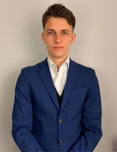 Modrá minimalistická ikona domečku s lupou, skrze lupu je vidět symbol dolaru.