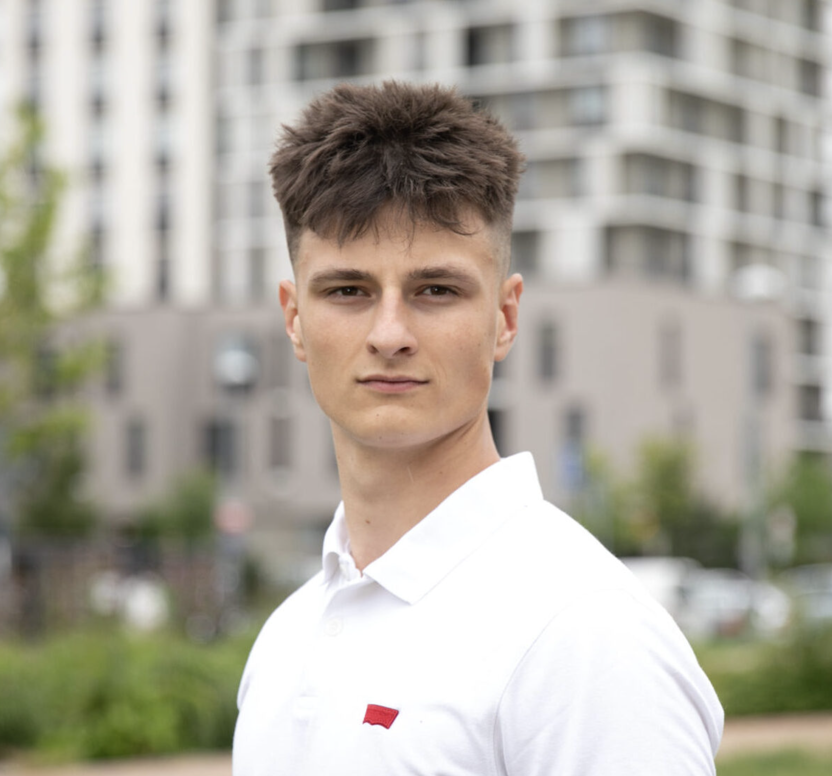 Modrá minimalistická ikona domečku s lupou, skrze lupu je vidět symbol dolaru.